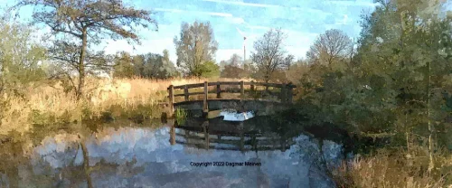 Eine Holzbrücke über eine Engstelle in einem Teich.